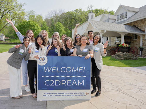 People posing with a banner that reads Welcome! C2DREAM