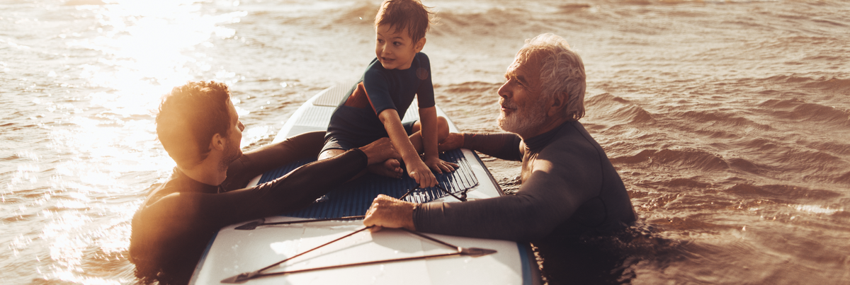 A father, son and grandfather paddle-boarding