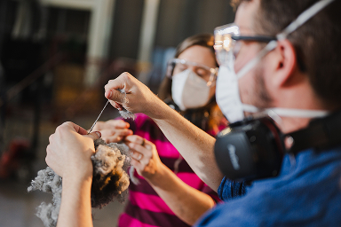 Students wearing masks while working in a textile lab