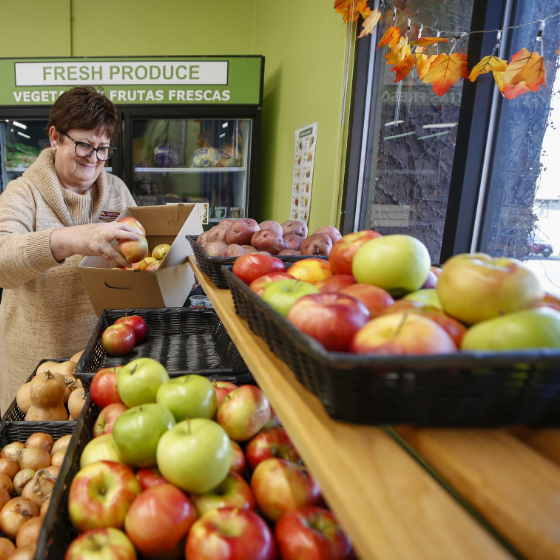 Dianne Davis-Kenning arranging apples on a shelf.