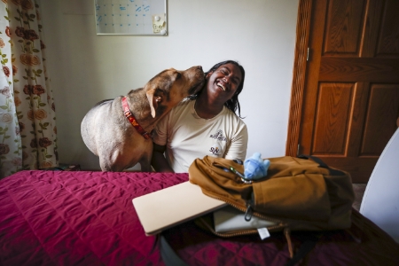 Akhil Kollengode's dog lovingly licks his face in a dorm room