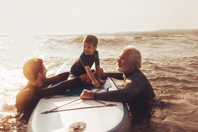 A father, son and grandfather paddle-boarding 