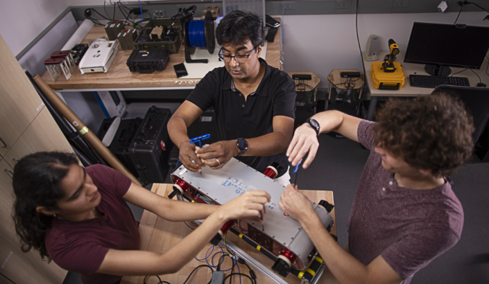 Sattar and his team work on the Minnebot on a workbench